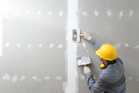 Plasterer working on wall